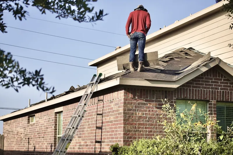 Professional roofer working on a residential roof in Monument